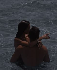 two people in the water hugging each other