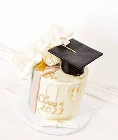 a graduation cake with a mortar and flowers on it's top, sitting on a plate