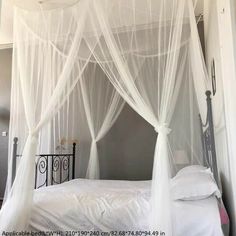 a canopy bed with white netting on it