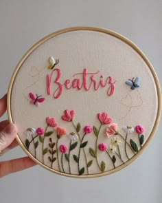 someone is holding up a embroidery kit that says,'beaties'with flowers and butterflies