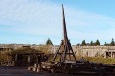 an old wooden structure in the middle of a field