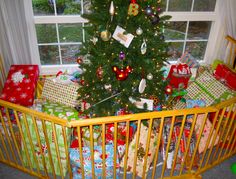 a baby crib with presents under a christmas tree