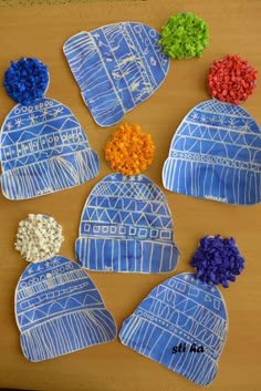 four hats made out of paper with flowers on them, all in blue and white