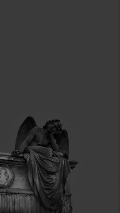 an angel statue sitting on top of a clock tower