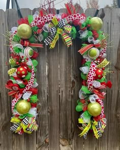 a christmas wreath hanging on the side of a wooden fence