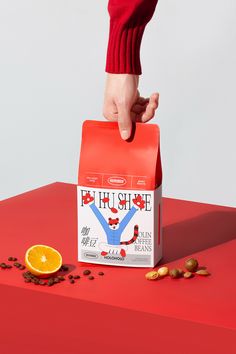 a person's hand reaching into a bag of coffee on top of a red table