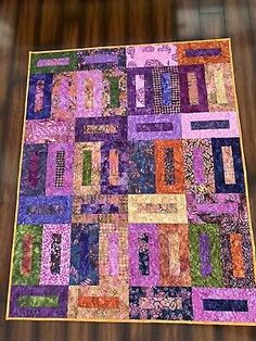 a purple and orange quilt on a wooden table