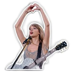 taylor swift is holding her guitar in the air