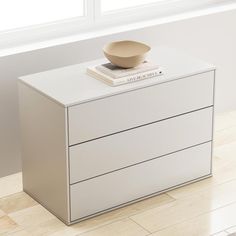 a white dresser with a bowl on top