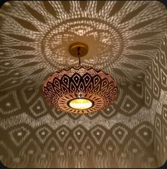 the light fixture is hanging from the ceiling in front of a wallpapered pattern