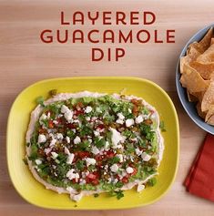 a yellow plate topped with guacamole next to a bowl of tortilla chips