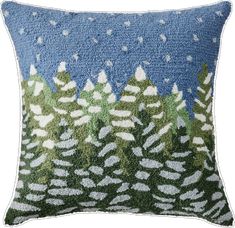 a blue and green pillow with trees on it