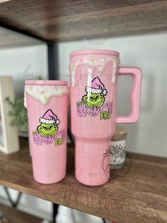 two pink tumblers with the words happy birthday on them sitting on top of a shelf