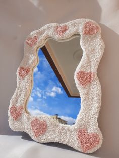 a mirror that has hearts on it in the shape of a heart, with a sky background