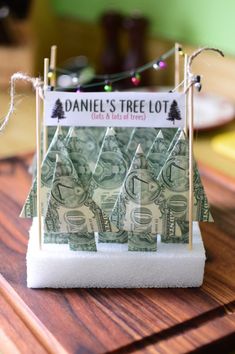 a money tree made out of dollar bills sitting on top of a wooden table