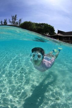 a man swimming in the ocean with goggles on