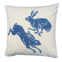 a blue and white pillow with an image of two rabbits on the back of it