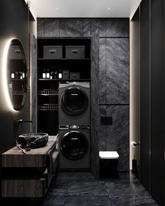 a washer and dryer in a bathroom with black tile flooring on the walls