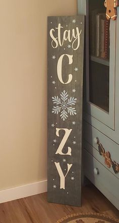 a wooden sign that says stay c'z y on it next to a blue cabinet