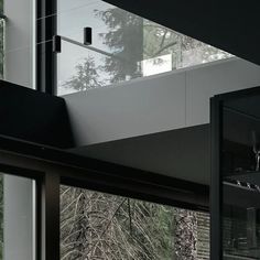 the interior of a modern house with glass walls and trees in the backround