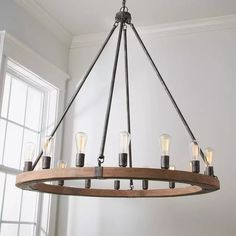 a chandelier made out of wood and metal with light bulbs hanging from it