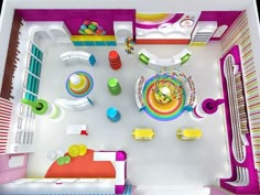 an aerial view of a colorful room with furniture and accessories on the floor, including a dining area