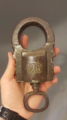 a person holding an old metal object in their hand