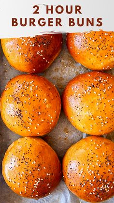 four hamburger buns with sesame seeds on top