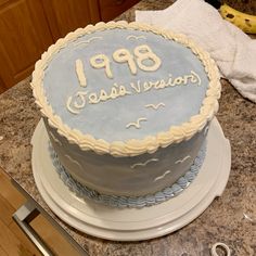 a blue and white birthday cake sitting on top of a counter next to a knife