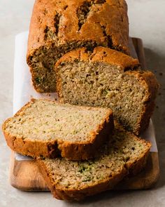 a loaf of zucchini bread on a cutting board with slices cut off the side