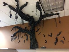 a tree with bats hanging from it's branches is in an office cubicle