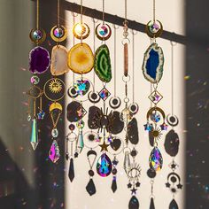 a wind chime hanging from a window with lots of different colored beads and jewels