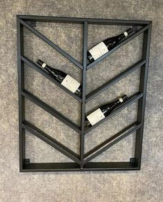 a wine rack with three bottles in it on the wall next to a carpeted floor