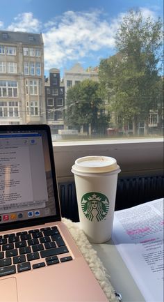 an open laptop computer sitting next to a cup of coffee