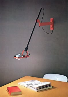 a desk with a lamp on top of it next to a book and some books