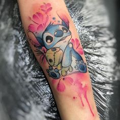 a watercolor style tattoo on the arm of a woman