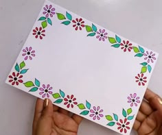 someone holding up a card with flowers on it