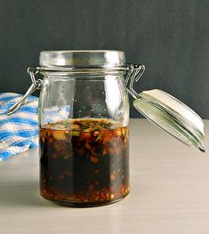 a glass jar filled with food sitting on top of a table next to a blue and white towel