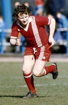 a young man running after a soccer ball