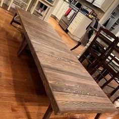 a wooden table sitting on top of a hard wood floor next to a kitchen counter