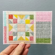 someone is holding up a small patchwork piece