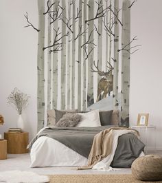 a bed room with a neatly made bed and a deer mural on the wall behind it