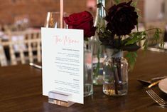 a table setting with flowers and menu cards