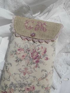 an old purse is sitting on a white sheet with lace and fabric trimmings