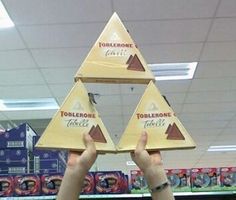 someone is holding up three pyramids in the store