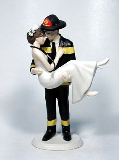 a wedding cake topper with a bride and groom holding each other in their arms