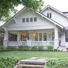 a white house with steps leading up to the front door and windows on each side