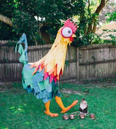 a large rooster standing on top of a lush green field