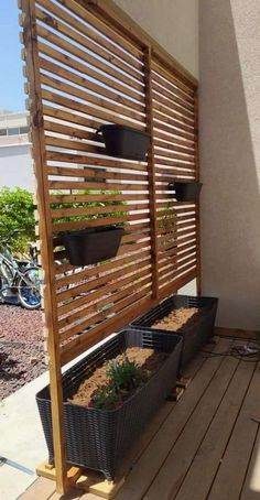 a wooden trellis with plants growing in it on top of a deck next to a building