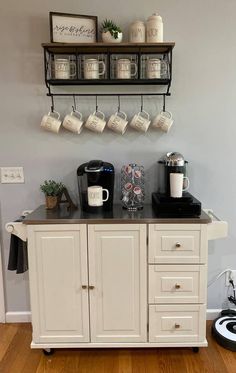 a coffee bar with cups hanging from the wall